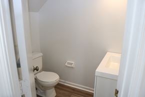 Virginia Beach house for rent - A white toilet is in a bathroom with a white sink.