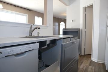 Virginia Beach house for rent - A kitchen with a white sink and grey cabinets.