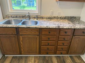 Wausau apartment for rent - A kitchen with granite countertops and wooden cabinets.