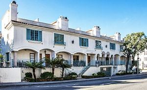 Los Angeles apartment for rent - A white building with green shutters and a black fence.