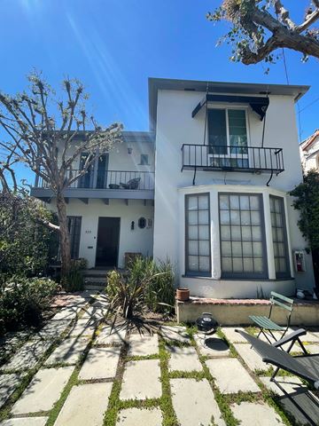 Los Angeles apartment for rent - A white house with a balcony and a tree in front.