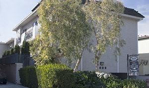Los Angeles apartment for rent - A white building with a black sign in front of it.