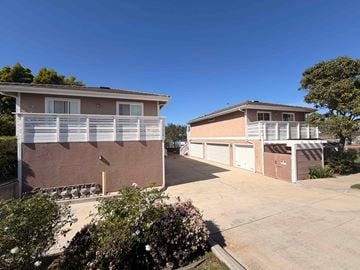 Dana Point apartment for rent - Two houses with garages are surrounded by greenery.