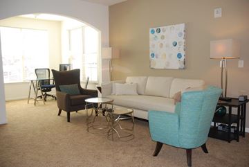 Waynesboro apartment for rent - A living room with a white couch, a blue chair, and a painting on the wall.