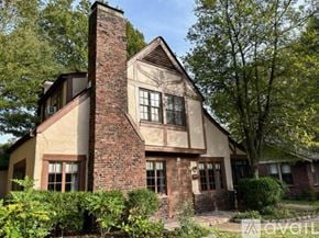 Memphis house for rent - A house with a red brick chimney and a large tree in front.