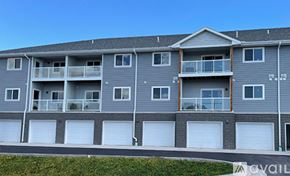 Rapid City apartment for rent - A grey apartment building with a balcony on the second floor.