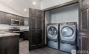 Rapid City apartment for rent - A modern kitchen with dark wood cabinets and a marble countertop.