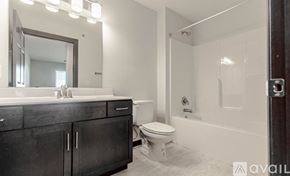 Rapid City apartment for rent - A bathroom with a white toilet and a white bathtub.