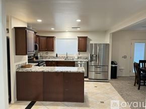 Santa Clarita house for rent - A kitchen with brown cabinets and a marble countertop.