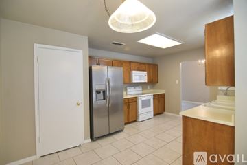 Temple house for rent - A kitchen with a white refrigerator and wooden cabinets.