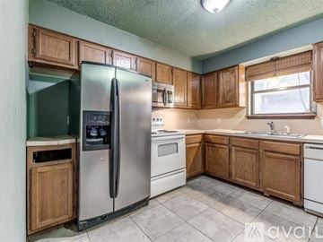 Oklahoma City house for rent - A kitchen with wooden cabinets and a stainless steel refrigerator.