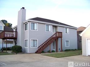 Virginia Beach condo for rent - A two-story house with a garage and a balcony.