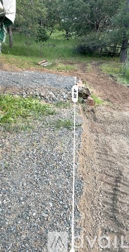 Jacksonville apartment for rent - A white pole with a sign on it stands in the middle of a gravel road.
