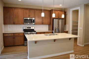 Vancouver house for rent - A kitchen with wooden cabinets and a white countertop.