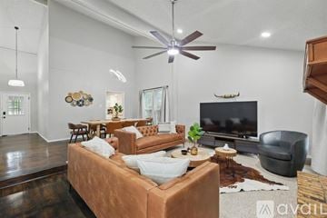 Garland house for rent - A living room with a brown couch and a television mounted on the wall.