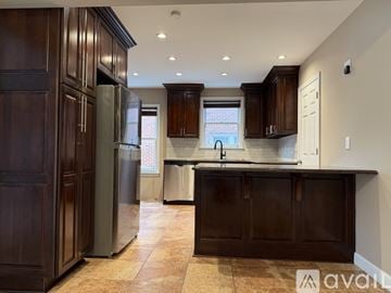 University Heights apartment for rent - A kitchen with dark wood cabinets and a tiled floor.
