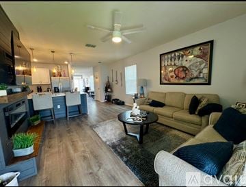 Kissimmee house for rent - A living room with a couch, coffee table, and a painting on the wall.