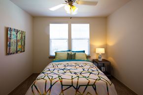 Denton apartment for rent - a bedroom with a bed and a ceiling fan