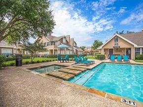 Irving apartment for rent - a swimming pool with blue chairs in front of a house