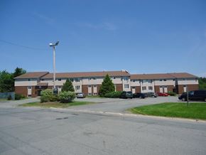 Dartmouth apartment for rent - A large building with a parking lot in front.