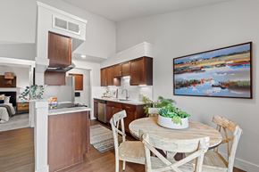 Carrollton apartment for rent - A kitchen with a table and chairs and a painting on the wall.