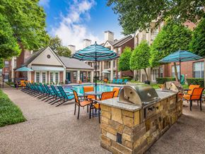Dallas apartment for rent - a resort style pool and patio with chairs and umbrellas