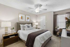 Dallas apartment for rent - a bedroom with a bed and a ceiling fan