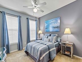 Plano apartment for rent - a bedroom with a bed and a ceiling fan