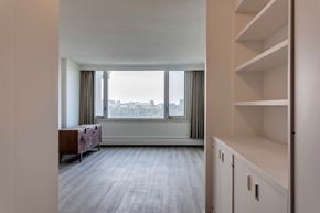 Edmonton apartment for rent - A room with a large window and a wooden cabinet.