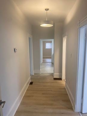 Bedford apartment for rent - A long hallway with a light on the ceiling and a door at the end.