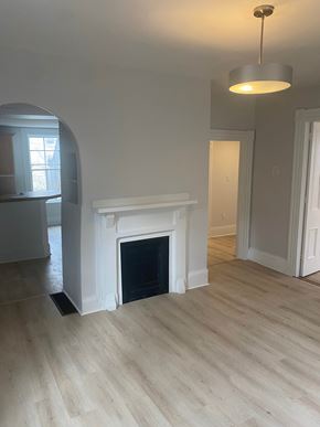 Bedford apartment for rent - A white fireplace in a room with light wood flooring.