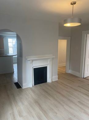 Bedford apartment for rent - A white fireplace in a room with light wood flooring.