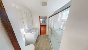 Wolfville apartment for rent - A bathroom with a toilet, sink, and a window.