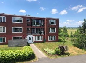 Wolfville apartment for rent - A red brick building with a white door and windows.