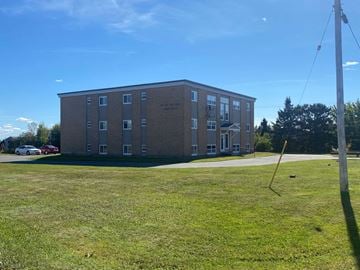 Springhill apartment for rent - A building with a grassy area in front of it.