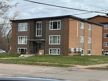 Amherst apartment for rent - A brown apartment building with a car parked in front.