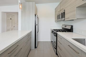 Coronado apartment for rent - A modern kitchen with a black stove top oven and a black refrigerator.