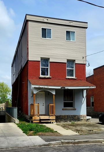 Ottawa apartment for rent - A two-story house with a red brick base and a beige upper level.