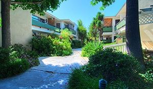 Los Angeles apartment for rent - A pathway surrounded by greenery leads to a building.