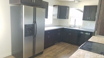 Rapid City house for rent - A kitchen with a stainless steel refrigerator and black cabinets.