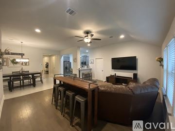 Robinson house for rent - A living room with a brown couch and a television on the wall.