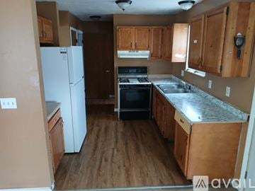 Toledo house for rent - A kitchen with wooden cabinets and a white refrigerator.