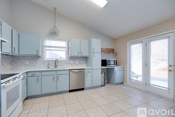 Dayton house for rent - A kitchen with blue cabinets and white appliances.