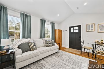 North Charleston house for rent - A living room with a grey couch and a black door.