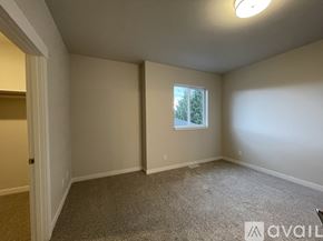 Wenatchee apartment for rent - A room with a carpeted floor and a window showing trees outside.
