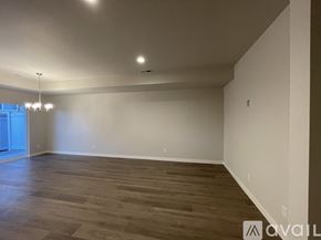 Wenatchee apartment for rent - A spacious room with wooden flooring and white walls.