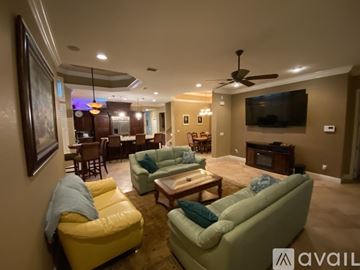 Titusville house for rent - A living room with a yellow chair and a green couch.