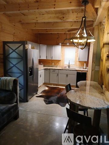 Nebo house for rent - A kitchen with a table and chairs in the foreground and a refrigerator in the background.