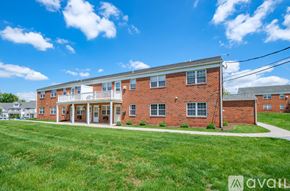 Millersville apartment for rent - A red brick building with a white porch and a sign that says "available".