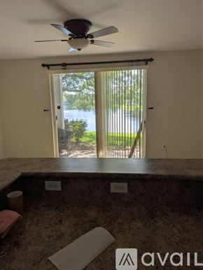 Miramar townhouse for rent - A room with a fan and a window overlooking a green area.